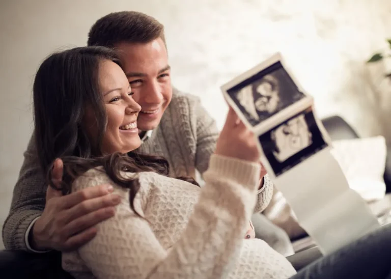 Parents looking at ultrasound images smiling