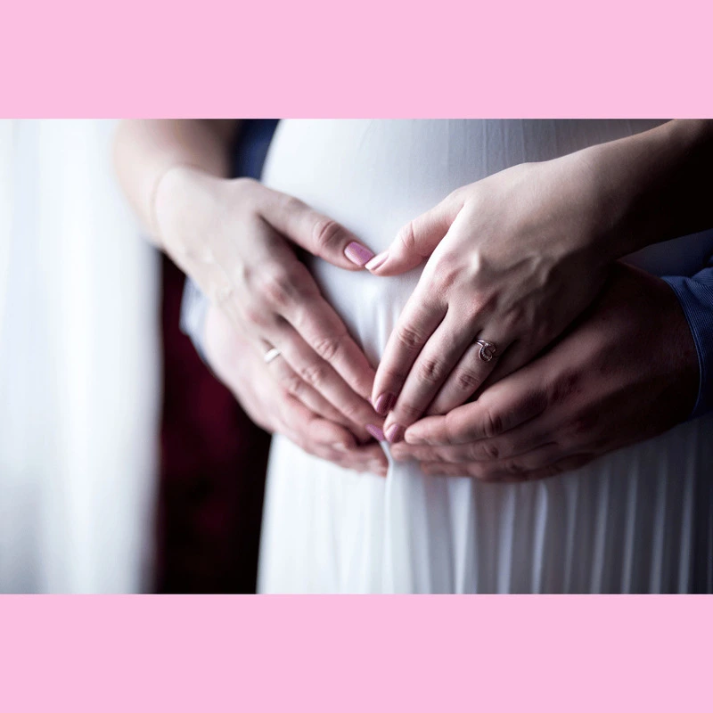 Woman holding hands around her stomach